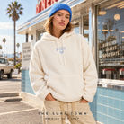 Sudadera sherpa Roxy Cool Calling Egret en diner vintage; imagen editorial propia de surf town