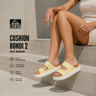 Fotografía propia de THE SURF TOWN de las sandalias Reef Cushion Bondi 2 Pale Banana para mujer en escaleras de hormigón modernas con estilo lifestyle premium y luz natural editorial