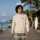 Sudadera Rip Curl Made For Vintage White para hombre en una escena tropical junto al océano, imagen editorial propia de THE SURF TOWN