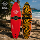 Tabla de Surf SurfWorx Hellcat Mini Mal 6.0 en fotografía editorial propia de THE SURF TOWN sobre arena junto al mar mostrando deck y bottom con diseño softboard para iniciación y progresión
