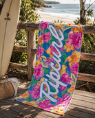 Toalla Rip Curl multicolor floral en escena beach lifestyle tropical premium