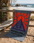 Toalla Rip Curl Sunstash Chrome en escena surf lifestyle premium junto a la costa