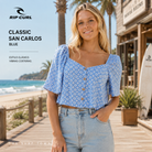 Top Rip Curl Classic San Carlos Blue en paseo marítimo surf lifestyle frente al mar, fotografía editorial propia de THE SURF TOWN con estilo femenino y ambiente costero premium