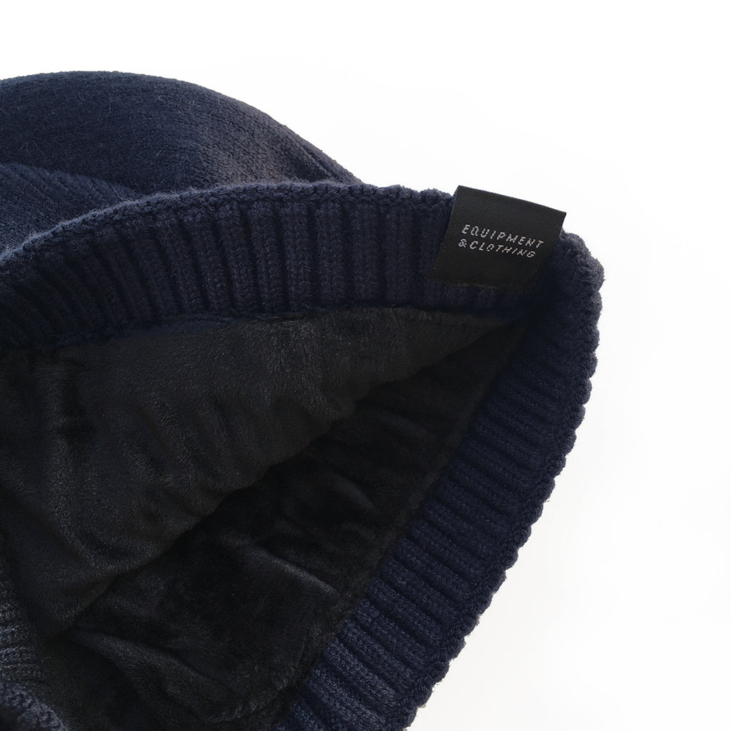 Gorro de punto elástico, de color azul marino marca The Surf Town con interior forrado de suave terciopelo y con etiqueta de la ola en el bajo.
