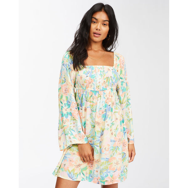 Vestido corto con mangas largas acampanadas estilo boho de estampado de flores tropicales en tonos pastel. Corte imperio con elástico, tejido arrugado fluido de viscosa.